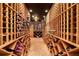Walk-in wine cellar with custom wooden racks, brick flooring, and dim lighting, creating an elegant space at 5045 Harrington Rd, Johns Creek, GA 30022