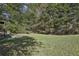 Lush green backyard featuring mature trees, a grassy lawn, and ample space for recreation at 915 Terance Ave, Jonesboro, GA 30238
