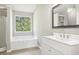 Bright bathroom featuring a soaking tub, a walk-in shower, a large vanity, and ample natural light at 915 Terance Ave, Jonesboro, GA 30238