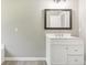 Bright bathroom featuring a single sink vanity, framed mirror, and neutral color palette at 915 Terance Ave, Jonesboro, GA 30238