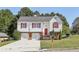 Charming two-story home featuring a two-car garage, red shutters and door, and a well-manicured front yard at 915 Terance Ave, Jonesboro, GA 30238