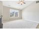 Bright, carpeted loft area with a large window, ceiling fan, and neutral paint tones, creating a versatile living space at 915 Terance Ave, Jonesboro, GA 30238