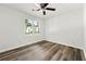 Bedroom featuring wood-look flooring, ceiling fan, and one window overlooking outside greenery at 2261 Wellington Cir, Lithonia, GA 30058
