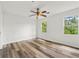 Bedroom features wood-look flooring, ceiling fan, and two windows overlooking outside greenery at 2261 Wellington Cir, Lithonia, GA 30058