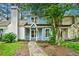 Charming two-story home with light blue siding, white trim, covered porch, and mature trees at 2261 Wellington Cir, Lithonia, GA 30058