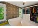 Freestanding tub positioned near windows with custom wallpaper and built-in closet at 3380 Canon Bay Dr, Cumming, GA 30041