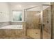 Bathroom featuring a glass enclosed shower and a large soaking tub with decorative tile surround at 3380 Canon Bay Dr, Cumming, GA 30041