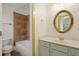 Bathroom featuring gray vanity, tile floors, and tub with shower; ornate framed mirror at 3380 Canon Bay Dr, Cumming, GA 30041