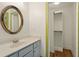 Bathroom featuring gray vanity and custom mirror; closet in background with wood floors at 3380 Canon Bay Dr, Cumming, GA 30041