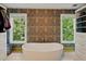 Bright bathroom featuring a standalone tub, two windows, and custom storage solutions at 3380 Canon Bay Dr, Cumming, GA 30041