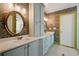 Inviting bathroom featuring double sinks, round mirrors, and decorative wall paper at 3380 Canon Bay Dr, Cumming, GA 30041