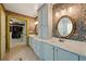 Inviting bathroom featuring double sinks, round mirrors, and decorative wall paper at 3380 Canon Bay Dr, Cumming, GA 30041