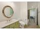 Bright bathroom featuring a single vanity, round mirror, and toilet with tile flooring at 3380 Canon Bay Dr, Cumming, GA 30041