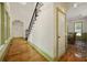 Hallway with staircase with wrought iron railings and hardwood floors leading to dining room at 3380 Canon Bay Dr, Cumming, GA 30041