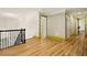 Upstairs hallway with hardwood floors leading to rooms with bright green trim; overhead chandelier at 3380 Canon Bay Dr, Cumming, GA 30041