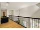 Hallway landing features wood floors, decorative railing and chair; overlooking lower level at 3380 Canon Bay Dr, Cumming, GA 30041