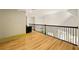 Hallway landing features wood floors, decorative railing, and a glimpse into rooms below at 3380 Canon Bay Dr, Cumming, GA 30041
