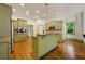 Bright kitchen features green cabinetry, stainless appliances, granite counters, and a central island at 3380 Canon Bay Dr, Cumming, GA 30041