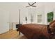 Bright bedroom features a fireplace and a ceiling fan above a four poster bed near a door to the outside at 3380 Canon Bay Dr, Cumming, GA 30041