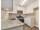 Well-lit kitchen featuring stainless steel appliances, granite countertops and white cabinets at 442 Cologne Se Dr, Atlanta, GA 30354