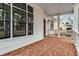 Classic front porch with brick flooring, white columns, and detailed window accents at 1271 Fenway Cir, Decatur, GA 30030