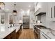 Beautiful kitchen features a large island with sink, stainless appliances and custom white cabinetry at 1271 Fenway Cir, Decatur, GA 30030