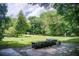 Expansive backyard featuring a stone barbecue area, lush greenery, and space for recreation at 1676 Moores Mill Nw Rd, Atlanta, GA 30327