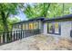 Gorgeous home exterior with stone patio and surrounding lush greenery creating a private oasis at 1676 Moores Mill Nw Rd, Atlanta, GA 30327