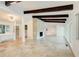 Spacious living room with beamed ceilings, a stone fireplace, and abundant natural light from large windows at 1676 Moores Mill Nw Rd, Atlanta, GA 30327