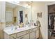 Bright bathroom featuring a double vanity, framed mirror and an adjacent walk-in closet at 2606 Fairmont Park Ct, Dacula, GA 30019
