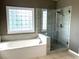 Bathroom featuring a soaking tub with a tiled surround and a glass-enclosed shower at 4091 Oberon Se Ct, Smyrna, GA 30080