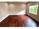 Bedroom with hardwood floors, light walls, and window with green tree view at 4091 Oberon Se Ct, Smyrna, GA 30080