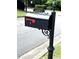 A closeup view of a black mailbox with gold lettering on a post with decorative accents at 4091 Oberon Se Ct, Smyrna, GA 30080