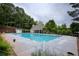 A luxurious community pool is surrounded by a large deck, mature trees, and a sun shelter at 4091 Oberon Se Ct, Smyrna, GA 30080