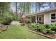Manicured backyard features lush landscaping, a brick patio, and charming planters at 491 Hemlock Sw Dr, Marietta, GA 30064