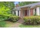 Inviting brick home featuring a red front door, bay window, and meticulously maintained landscaping at 491 Hemlock Sw Dr, Marietta, GA 30064