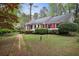 Charming one-story brick home with lush landscaping and a brick pathway to the front door at 491 Hemlock Sw Dr, Marietta, GA 30064