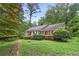 Charming single-story home with red shutters surrounded by lush greenery and mature trees in a tranquil setting at 491 Hemlock Sw Dr, Marietta, GA 30064