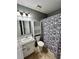 Bathroom with granite countertop and tile floor, and postage stamp patterned shower curtain at 1736 Almand Creek Sw Dr, Conyers, GA 30094