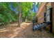 A home's backyard features stairs leading to a deck and a spacious grassy area with mature trees at 2683 Stardust Trl, Decatur, GA 30034