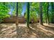 Exterior brick home featuring a large yard with mature trees and a charming deck at 2683 Stardust Trl, Decatur, GA 30034