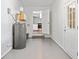 Unfinished basement area with painted floor, water heater, and view into the kitchen at 2683 Stardust Trl, Decatur, GA 30034