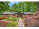 Charming brick home featuring a well-manicured lawn, garden, and a welcoming stone walkway at 3270 Leslie Ne Ct, Atlanta, GA 30345