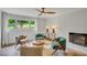 Comfortable sitting area featuring a brick fireplace, light tile floors, a ceiling fan, and natural light at 3270 Leslie Ne Ct, Atlanta, GA 30345