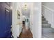 Inviting foyer with hardwood floors, stylish light fixture, staircase, and blue front door at 3992 Camden Way, Alpharetta, GA 30005