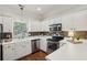 White kitchen features stainless steel appliances, a window and sleek countertops at 3992 Camden Way, Alpharetta, GA 30005