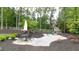 Landscaped backyard featuring a stone patio with dining set and a play set at 604 Trinity Church Rd, Canton, GA 30115