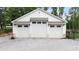 A three-car garage featuring white doors, brick accents, and ample parking space at 604 Trinity Church Rd, Canton, GA 30115