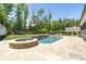 Resort-style pool and spa with a stone deck, lush lawn and mature trees at 604 Trinity Church Rd, Canton, GA 30115