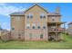 Rear exterior view of a two-story house with brick foundation, lawn, and covered deck, perfect for outdoor entertaining at 113 Osier Dr, Mcdonough, GA 30252